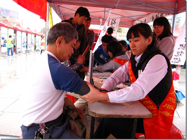 同学们认真为市民量血压